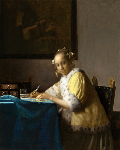 A printed art piece depicting a woman in historical clothing writing a letter, framed in a black frame.