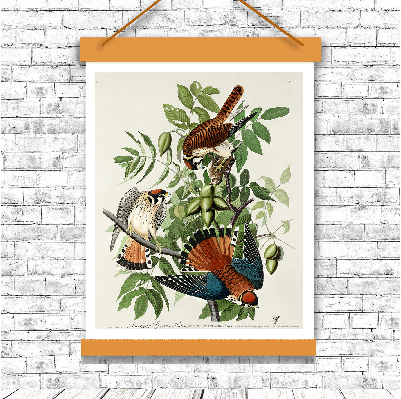 Decorative poster with birds and leaves on a white brick wall.