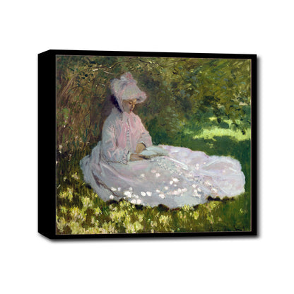 A printed art piece featuring a woman in a pink dress seated in a garden, framed in a black frame.