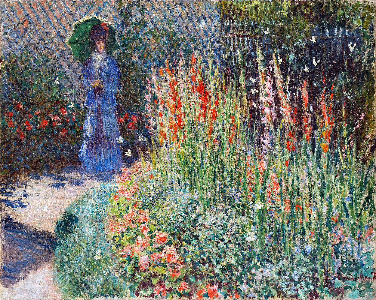 A framed print of a painting depicting a person in a blue dress walking among vibrant flowers with a pathway and a fence in the background.
