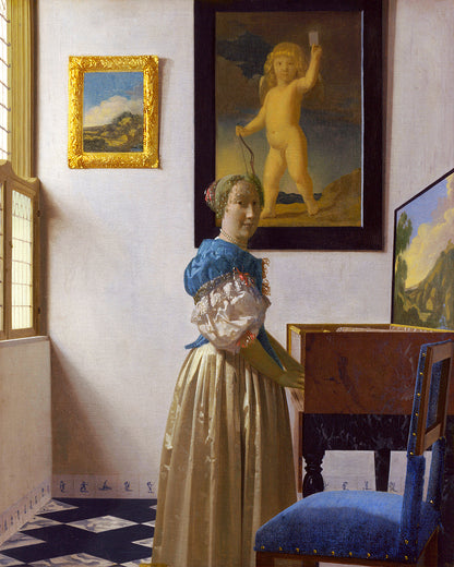 A framed print of 'Lady Standing at a Virginal' by Johannes Vermeer, depicting a woman in historical attire standing near a musical instrument, with a decorative board and a picture of an angel on the wall in the background.