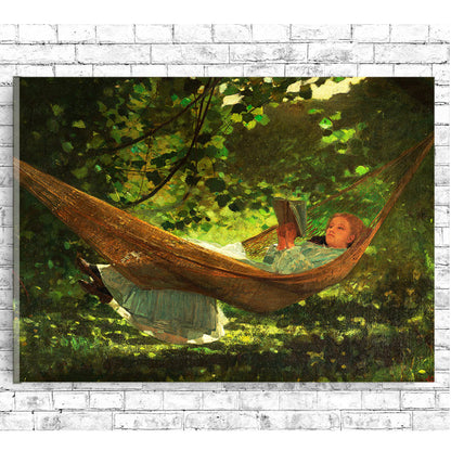 A printed art piece featuring two children relaxing in a hammock, surrounded by greenery, framed in a wooden frame with a white border.
