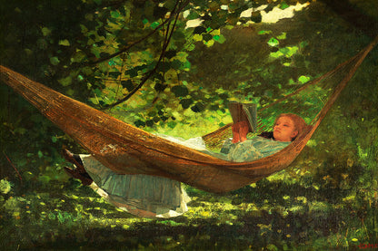 A printed art piece featuring two children relaxing in a hammock, surrounded by greenery, framed in a wooden frame with a white border.