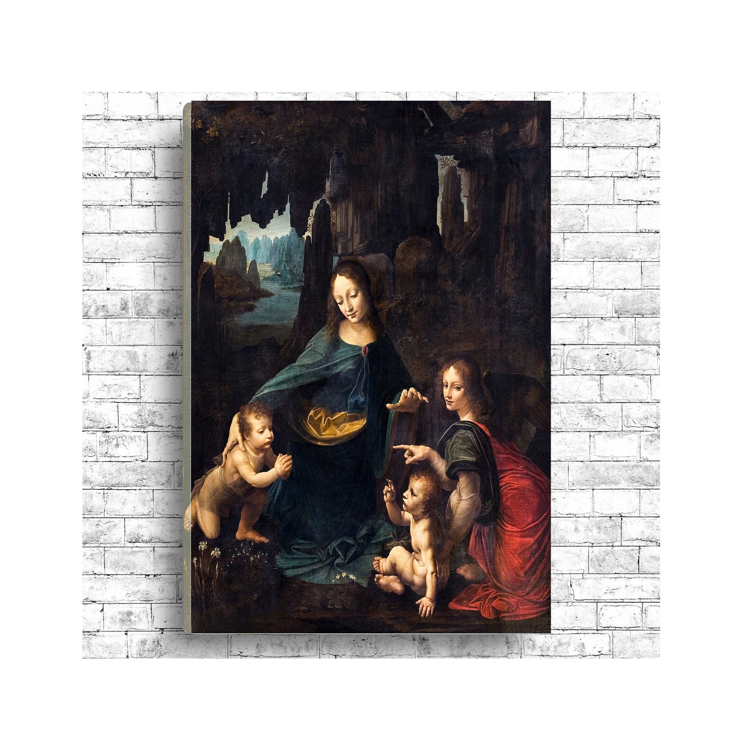 A framed print of 'The Virgin of the Rocks' by Leonardo Di Vinci, depicting the Virgin Mary with two children and an angel in a cave setting.