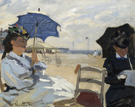 A framed print of 'The Beach at Trouville' by Claude Monet, depicting two women on a beach with a focus on the artwork within the frame.