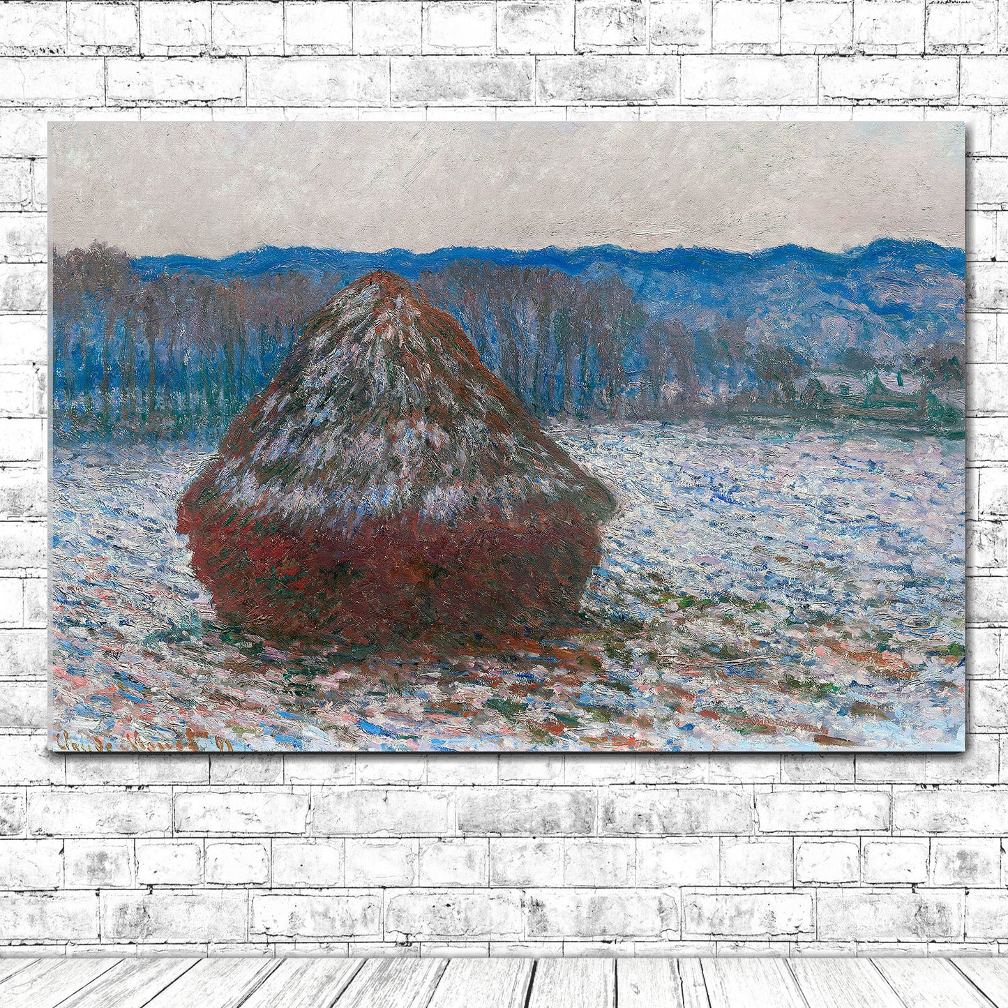 A printed art piece featuring 'Haystacks' by Claude Monet, with a red haystack in the foreground and a blue-toned landscape in the background, framed in a simple black frame.