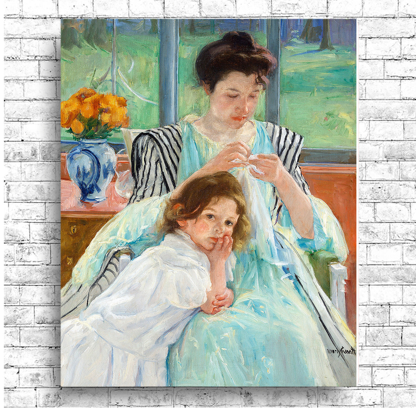 A framed print depicting a mother and child, with the mother sewing. The child is sitting beside her, looking towards the viewer.