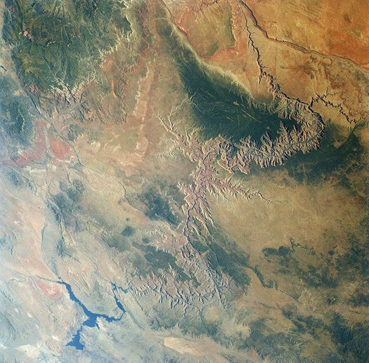 A satellite image of the Grand Canyon, showcasing its geological features with a muted color palette.