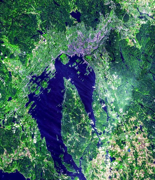A satellite image of Oslo, Norway, showcasing the city and surrounding areas with varying shades of green and blue.