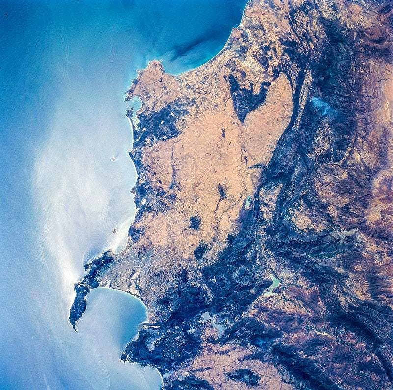 A satellite image of South Africa's coast, featuring Earth's curvature and detailed landmass in a colorized representation.