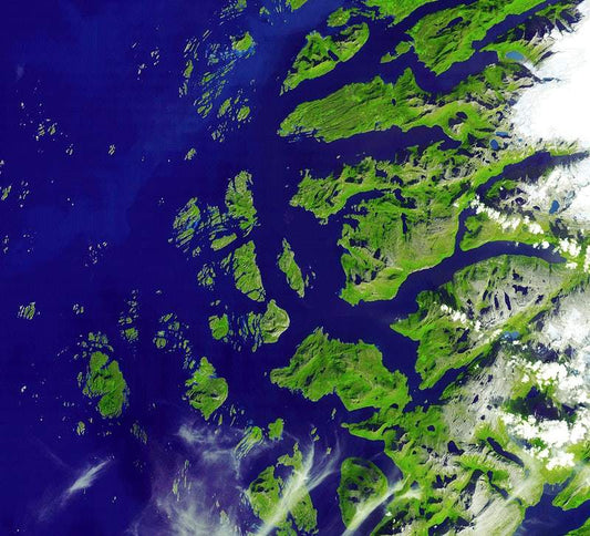 A satellite image of the Arctic Circle showing green landmasses and blue waters, with some cloud formations.