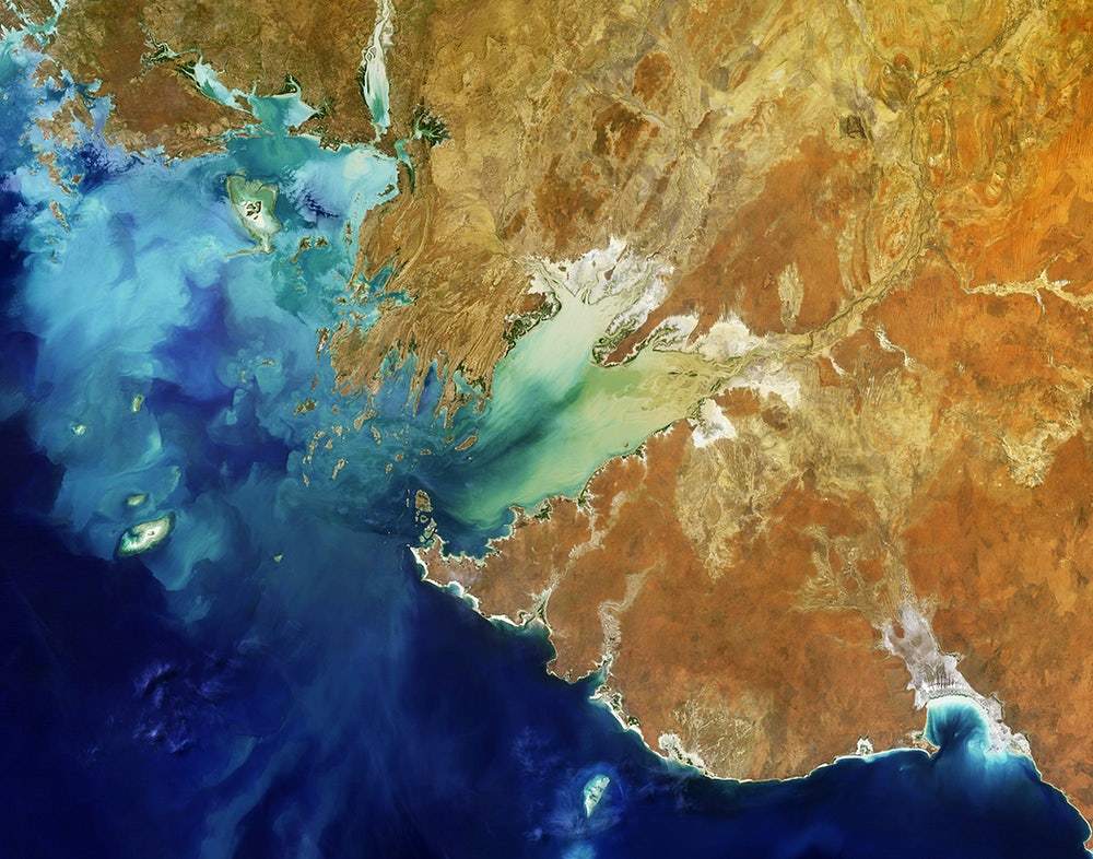 A satellite image of Western Australia featuring various colors representing different terrains and bodies of water.