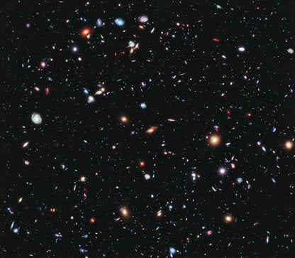 A print of a deep space image featuring numerous galaxies and celestial bodies against a black background.