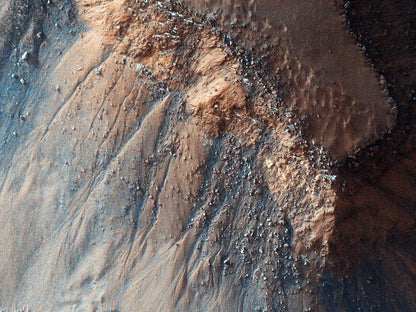 A close-up image of the Martian surface, showing a rugged landscape with varying shades of tan, beige, and red.